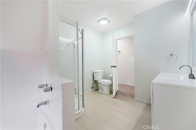 full bathroom with vanity, wood finished floors, baseboards, a shower stall, and toilet