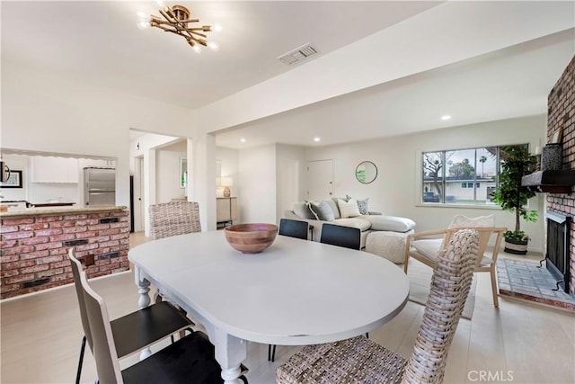 dining room featuring visible vents, recessed lighting, and a fireplace