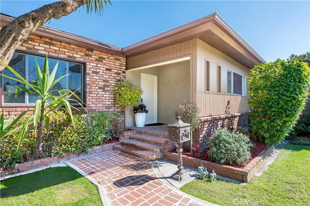 entrance to property with brick siding and stucco siding