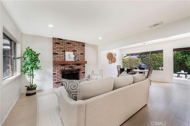 living area featuring light wood-style flooring, visible vents, and a wealth of natural light