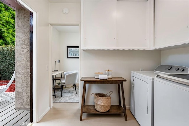 laundry area with cabinet space, light wood-style floors, and washing machine and dryer