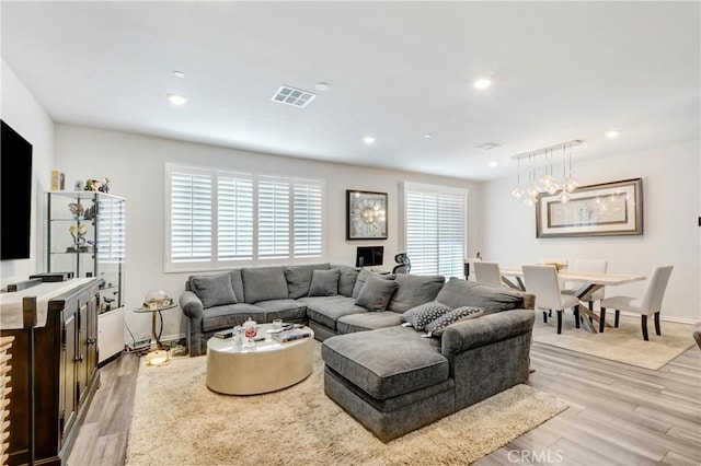 living area featuring visible vents, baseboards, a chandelier, light wood-type flooring, and recessed lighting