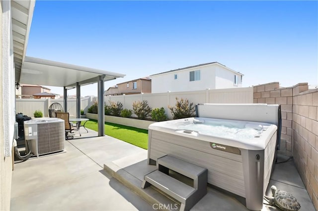 view of patio / terrace with a fenced backyard, central AC unit, outdoor dining space, and a hot tub