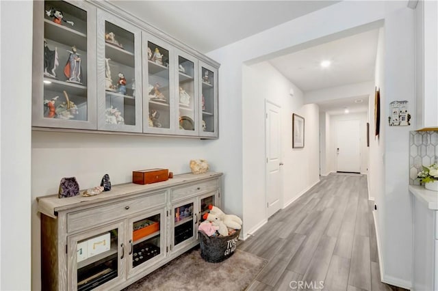 corridor featuring baseboards and wood finished floors