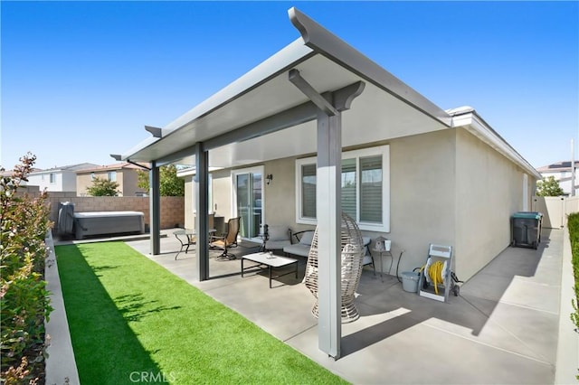 rear view of house featuring a fenced backyard, stucco siding, a yard, and a patio