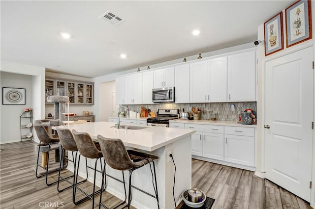 kitchen with visible vents, backsplash, appliances with stainless steel finishes, and a sink