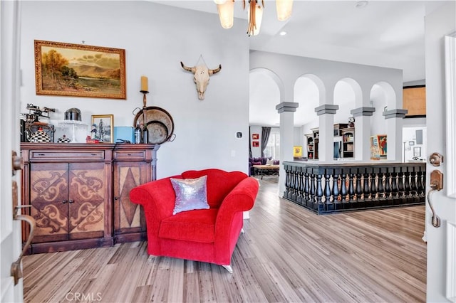 sitting room with recessed lighting, wood finished floors, and ornate columns
