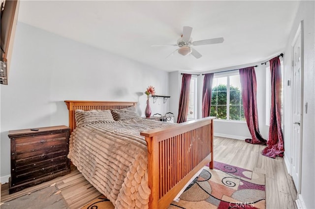 bedroom featuring baseboards, a ceiling fan, and wood finished floors