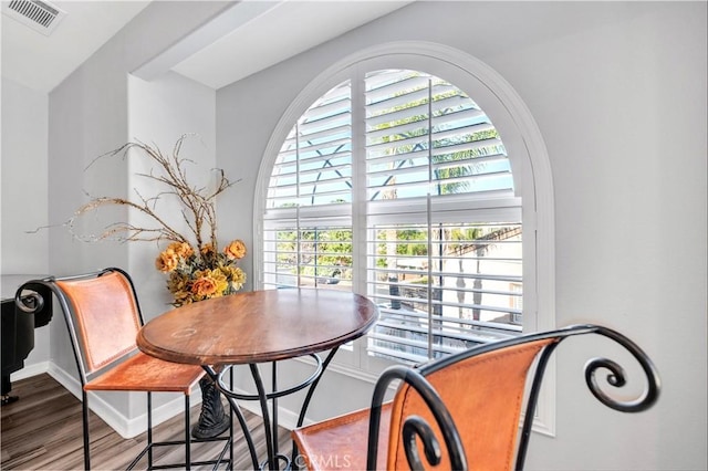 dining space with wood finished floors, visible vents, and baseboards