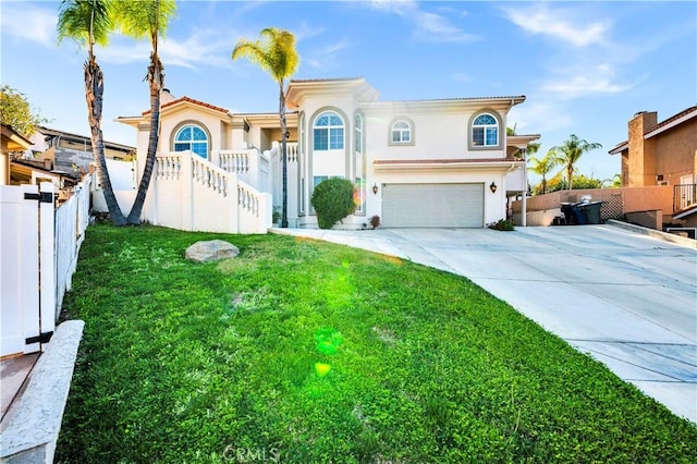 mediterranean / spanish-style home featuring fence, a front lawn, stucco siding, concrete driveway, and a garage