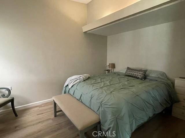 bedroom with baseboards and wood finished floors