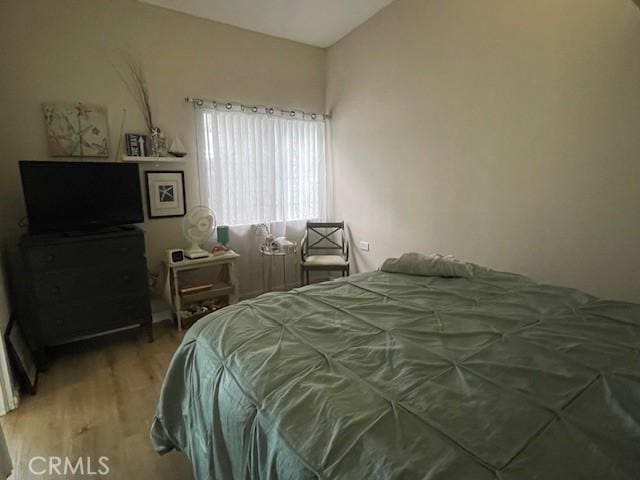 bedroom with lofted ceiling and wood finished floors