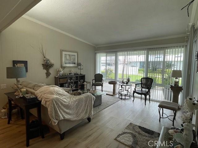 living area featuring crown molding and wood finished floors