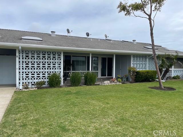 single story home featuring a front yard and roof with shingles