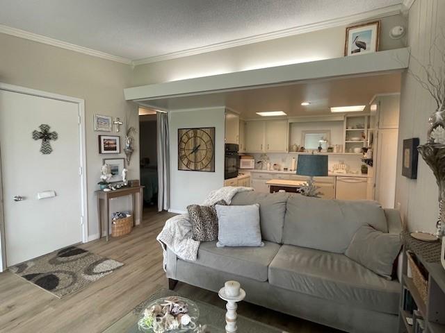 living room featuring light wood finished floors and ornamental molding