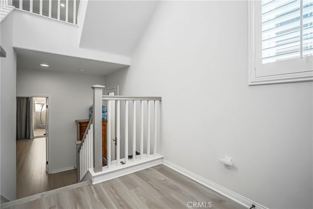 staircase with baseboards and wood finished floors