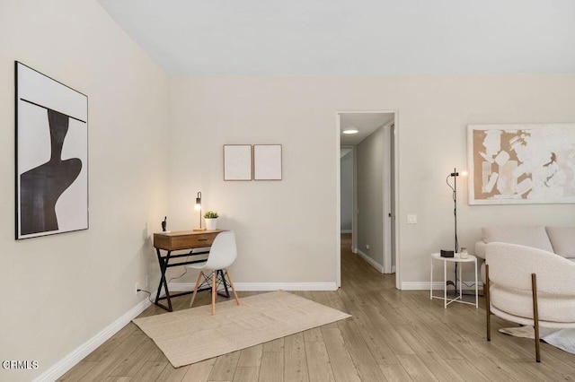 living area with baseboards and wood finished floors