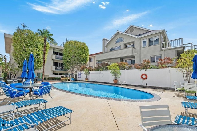 community pool featuring a patio and fence