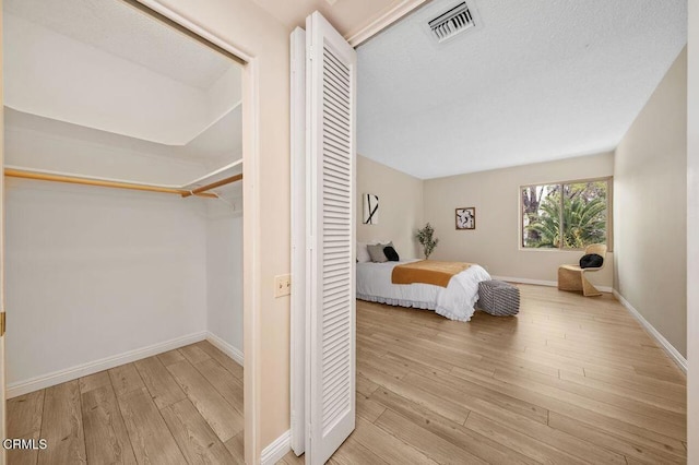 unfurnished bedroom featuring visible vents, baseboards, and wood-type flooring