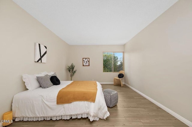 bedroom with baseboards and wood finished floors