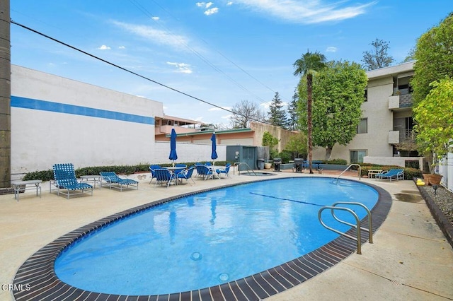 pool featuring fence and a patio area