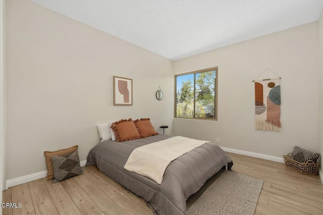 bedroom with baseboards and light wood finished floors