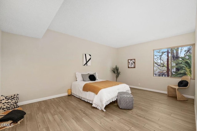 bedroom with baseboards and light wood-type flooring