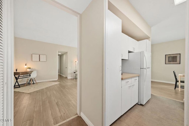 hallway with light wood finished floors and baseboards