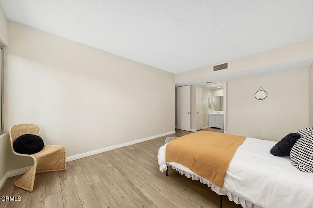 bedroom with visible vents, baseboards, and light wood-style floors