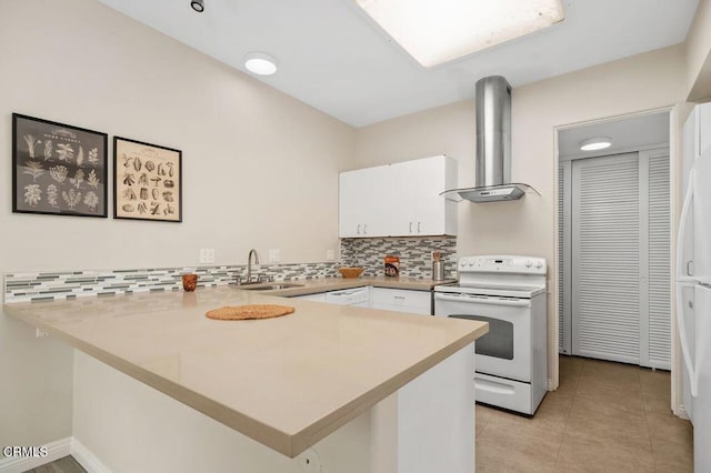 kitchen featuring a peninsula, white range with electric stovetop, white cabinets, wall chimney exhaust hood, and a sink