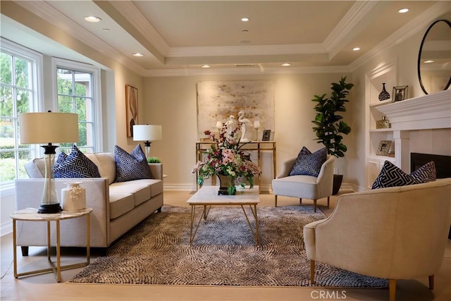 interior space featuring built in features, a tray ceiling, recessed lighting, a fireplace, and crown molding