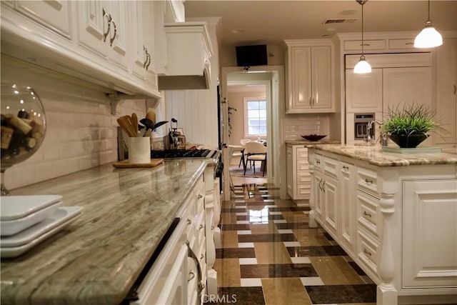 kitchen with visible vents, backsplash, appliances with stainless steel finishes, and white cabinetry