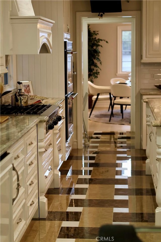 kitchen with premium range hood, stainless steel appliances, and light stone countertops