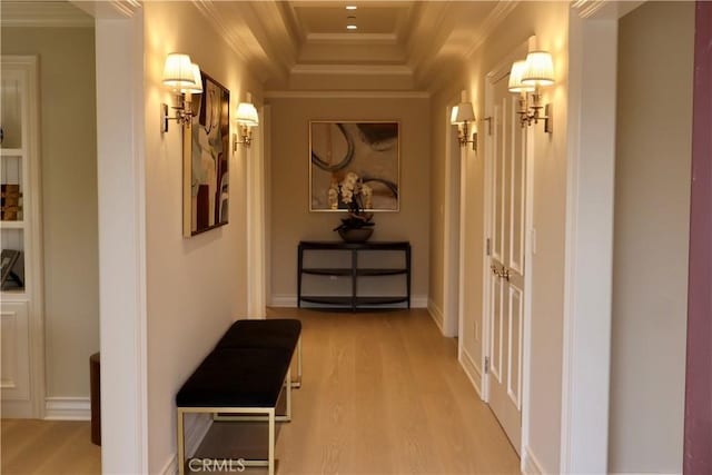 hallway featuring baseboards, wood finished floors, and ornamental molding