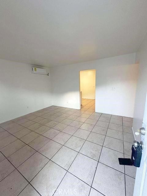 unfurnished room featuring light tile patterned floors and a wall mounted AC