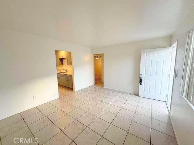 empty room featuring light tile patterned floors and a sink