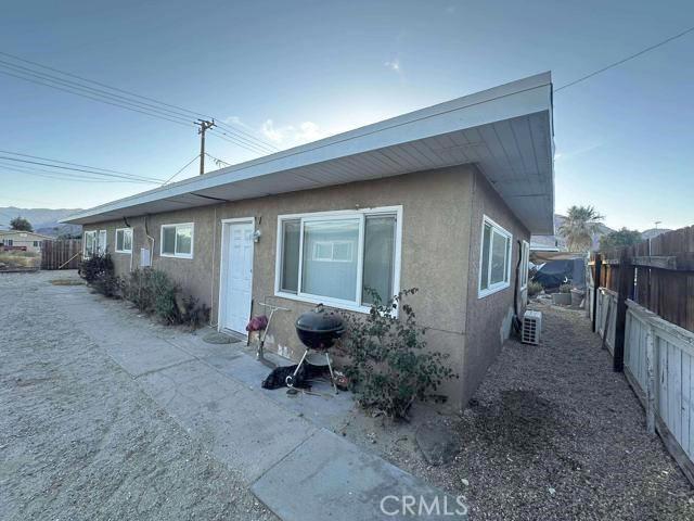 exterior space with stucco siding and fence