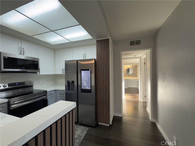 kitchen featuring dark wood-style floors, visible vents, white cabinets, and appliances with stainless steel finishes