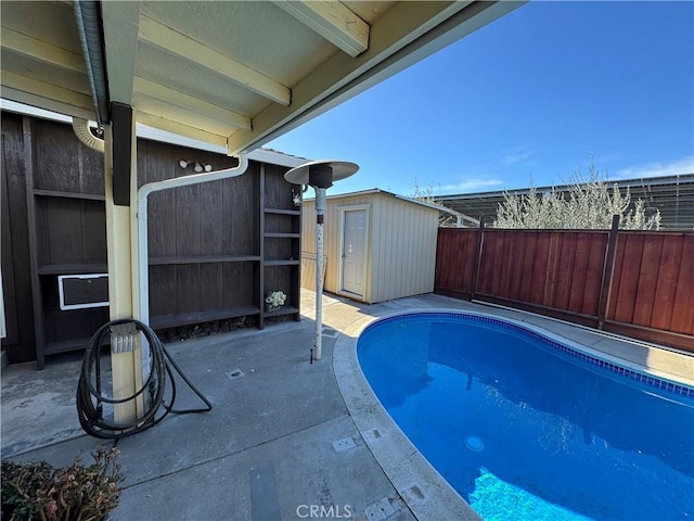 view of swimming pool featuring a fenced in pool, fence, a shed, an outbuilding, and a patio