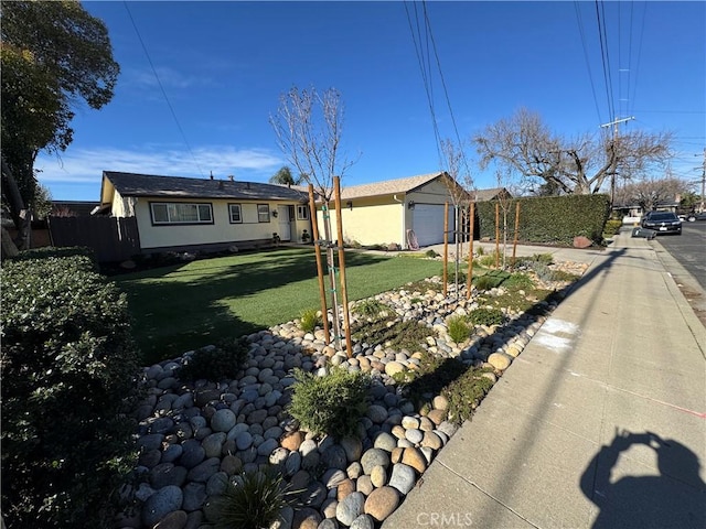 single story home with a front yard, a garage, and fence