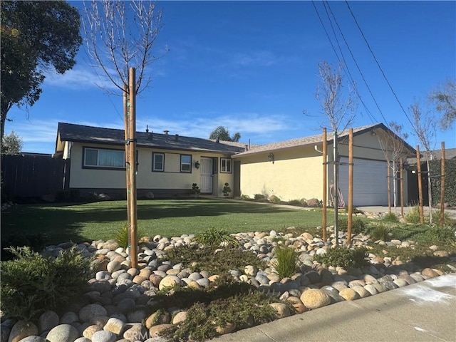 single story home featuring a front lawn, an attached garage, and stucco siding