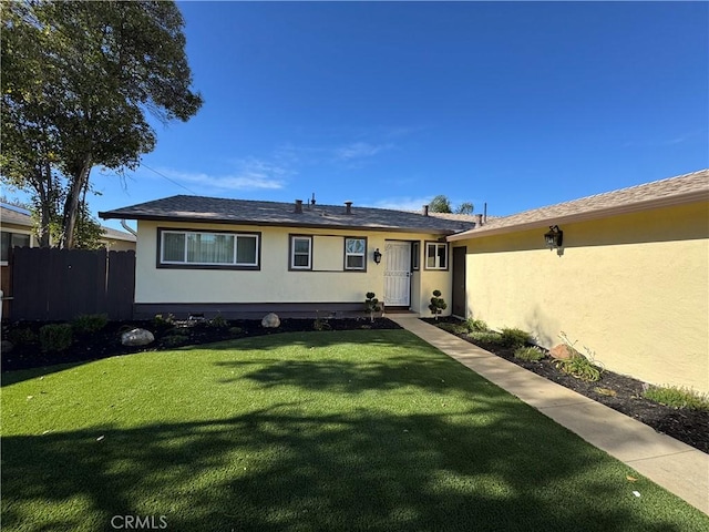 view of front facade featuring a front lawn, fence, and stucco siding