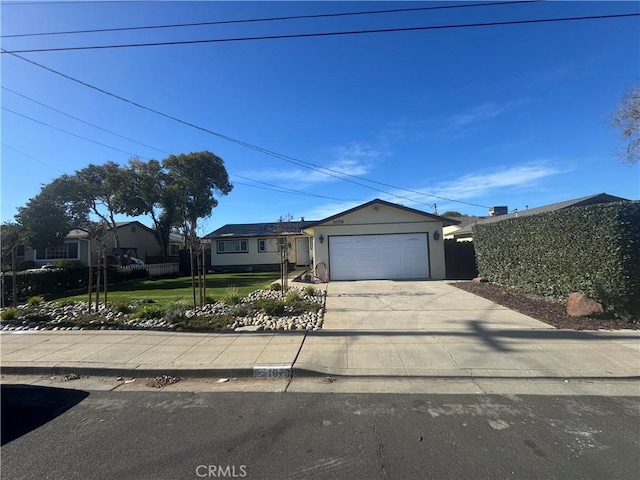 single story home with a front yard, an attached garage, driveway, and stucco siding