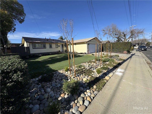 ranch-style house with a front lawn, fence, and a garage