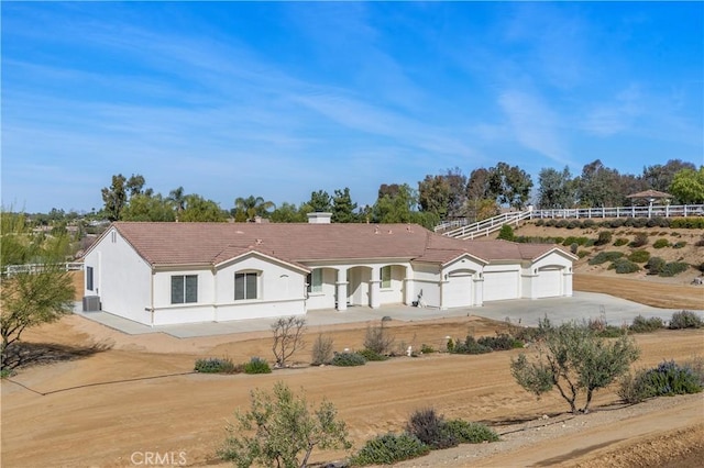 view of front of home with a garage, driveway, stucco siding, and a tile roof
