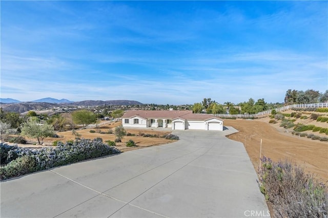 view of front of property with a mountain view and concrete driveway