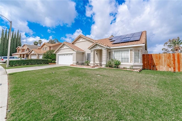 view of front of home with a front yard, fence, driveway, a garage, and roof mounted solar panels