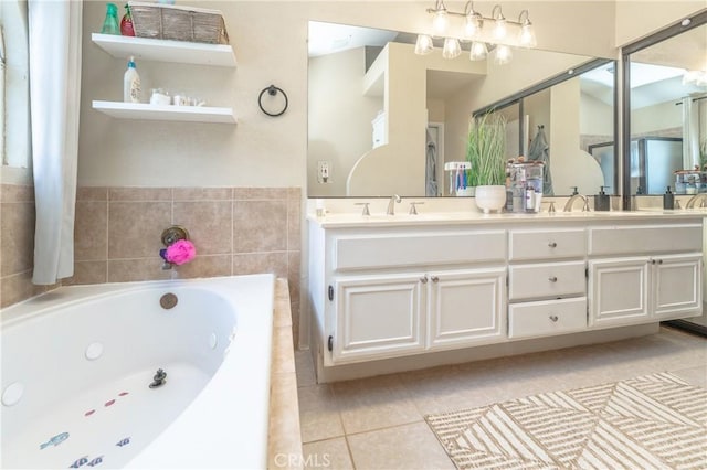 bathroom with a sink, a tub with jets, double vanity, and tile patterned floors