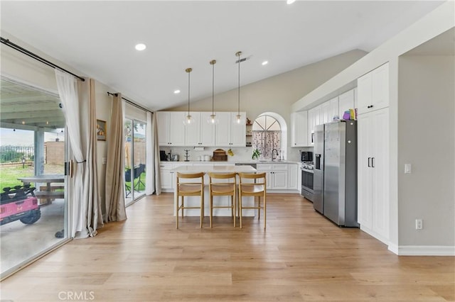 kitchen featuring light countertops, white cabinets, stainless steel fridge, and a kitchen island