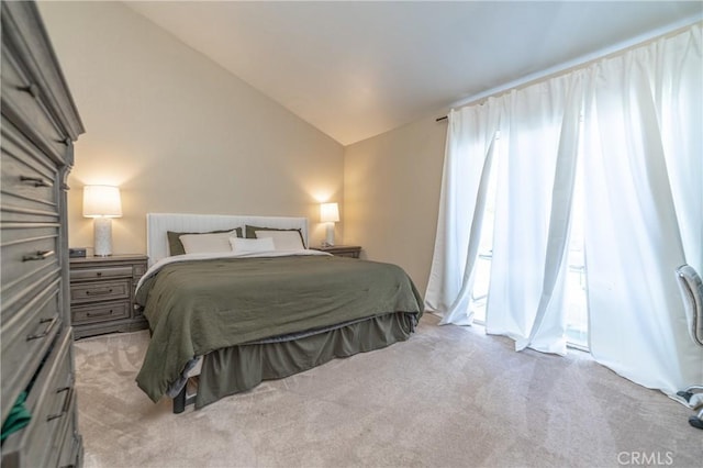 bedroom featuring light colored carpet and vaulted ceiling